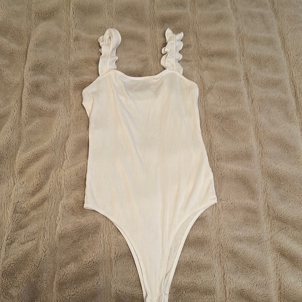 Adorable white body suit with ruffle straps